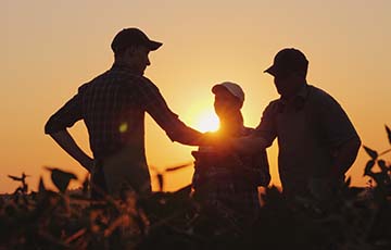 Three people in a field of crops